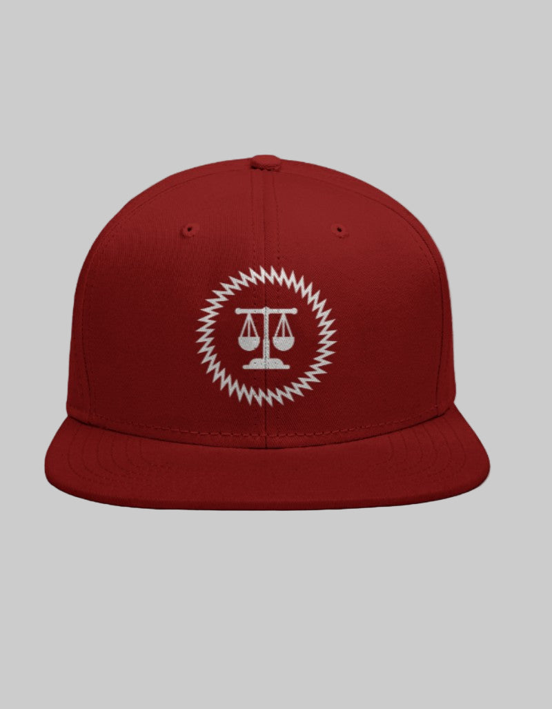 Red snapback cap with a white balanced scales icon inside a geometric circular border.