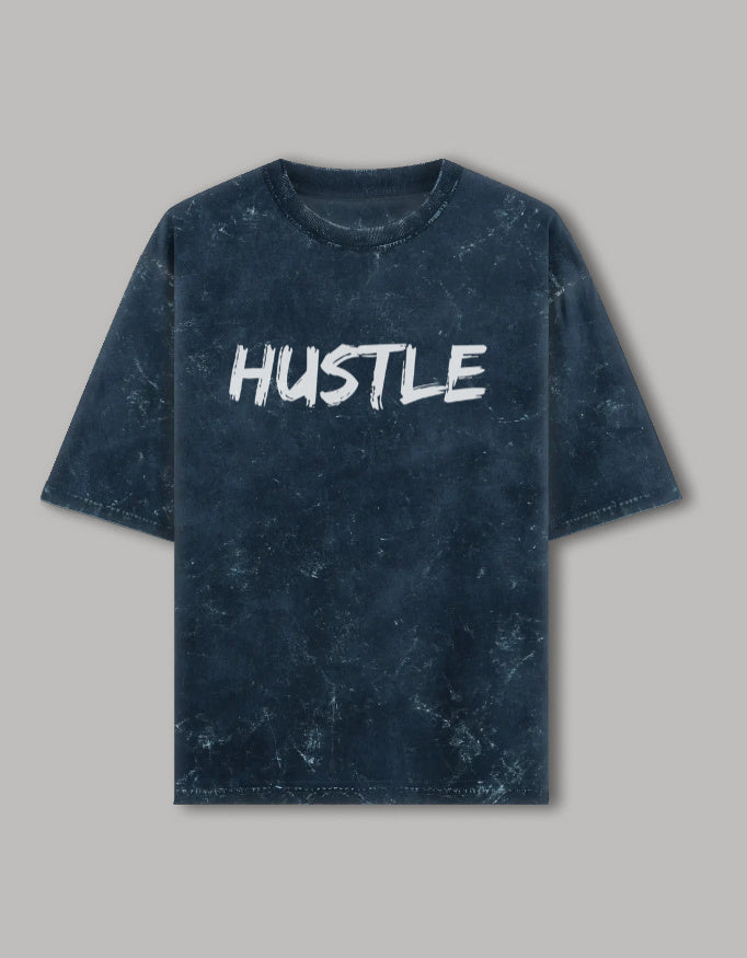 Acid wash oversized t-shirt with bold white "HUSTLE" graphic printed on front, streetwear style
