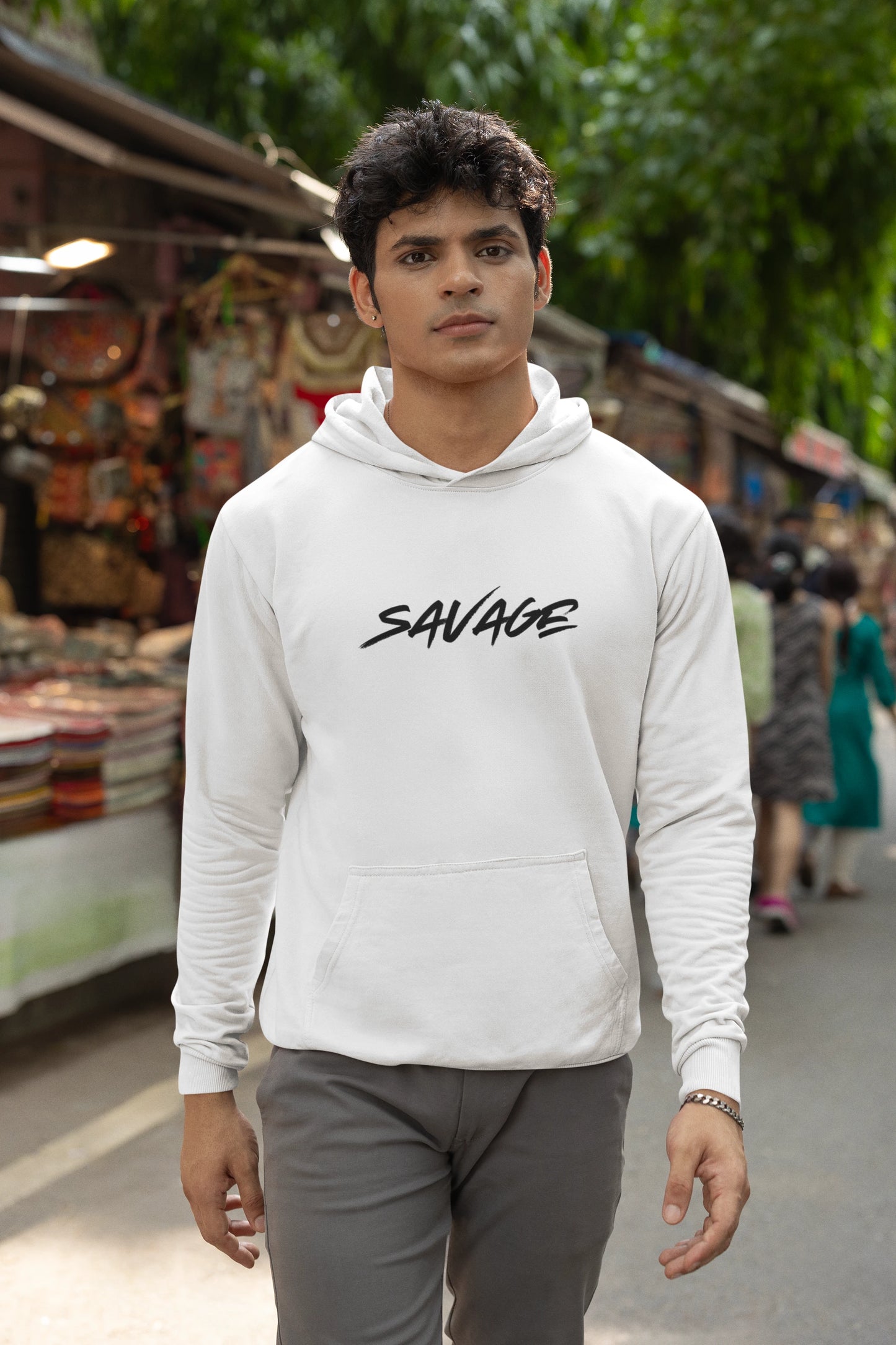 Man wearing a white hoodie with 'SAVAGE' text in an outdoor setting