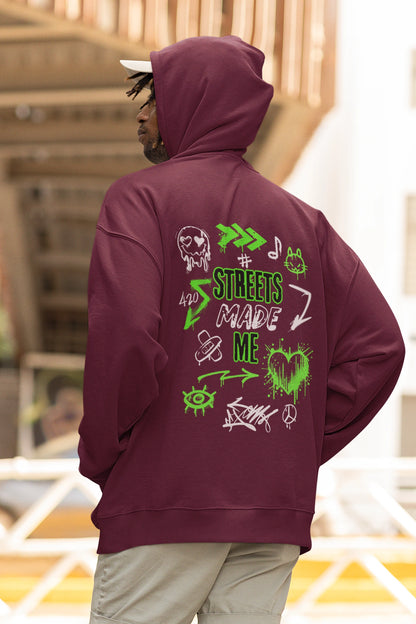 Person wearing a maroon hoodie with green graphics and text on the back, standing in an outdoor setting.