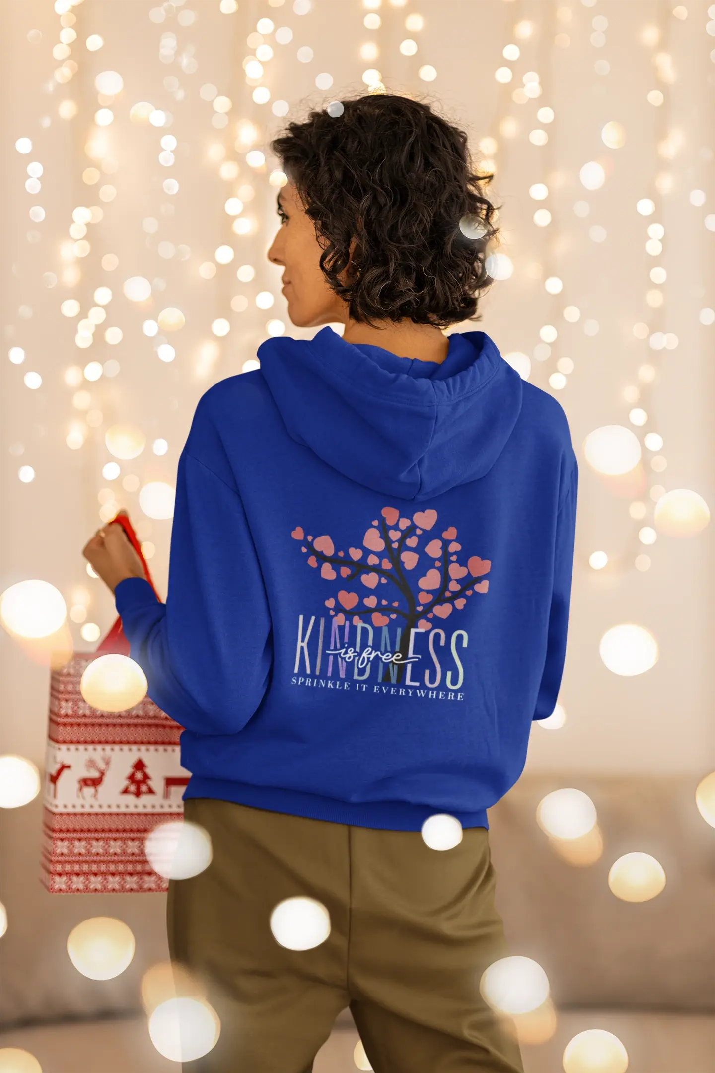 Chill streetwear vibes — woman in oversized hoodie flashing a peace sign, captured in comfy home mood