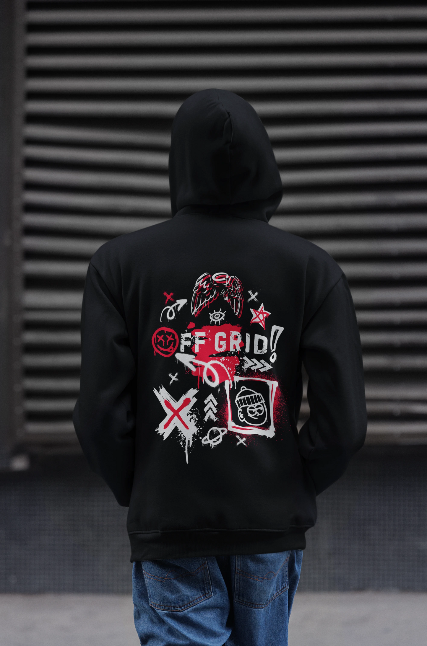 Person wearing a black hoodie with a graphic design on the back against a dark background