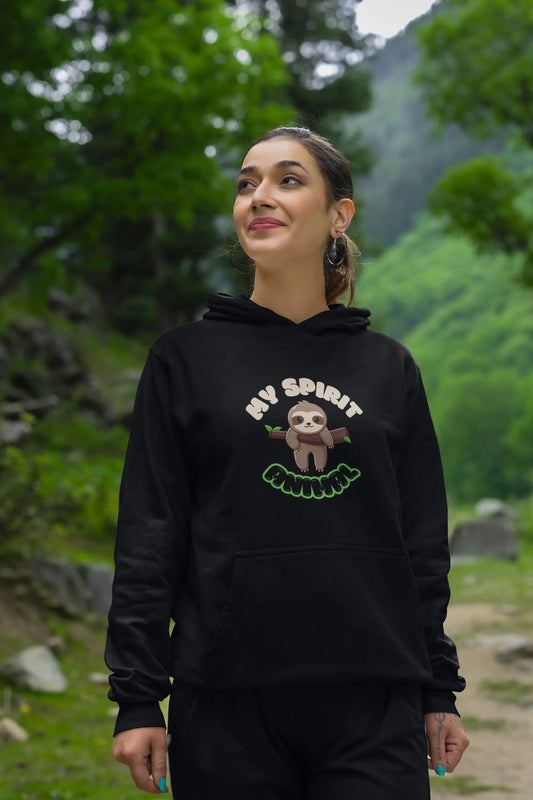 Woman wearing a black hoodie with a sloth graphic and text in a natural setting