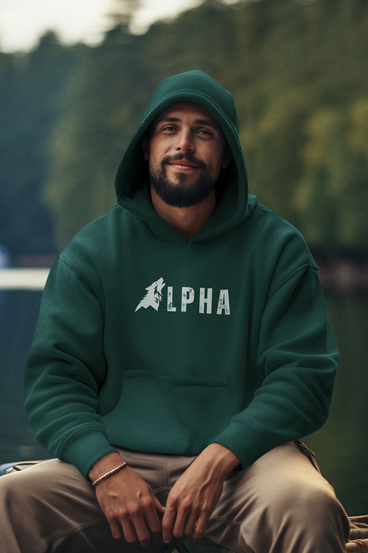 Man wearing a green hoodie with 'ALPHA' logo sitting outdoors.